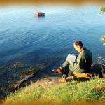 Man Reading Book By Sea Shore. East Point, Saturna Island, Gulf Islands BC.